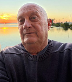 Headshot of Randy with a sunset behind him